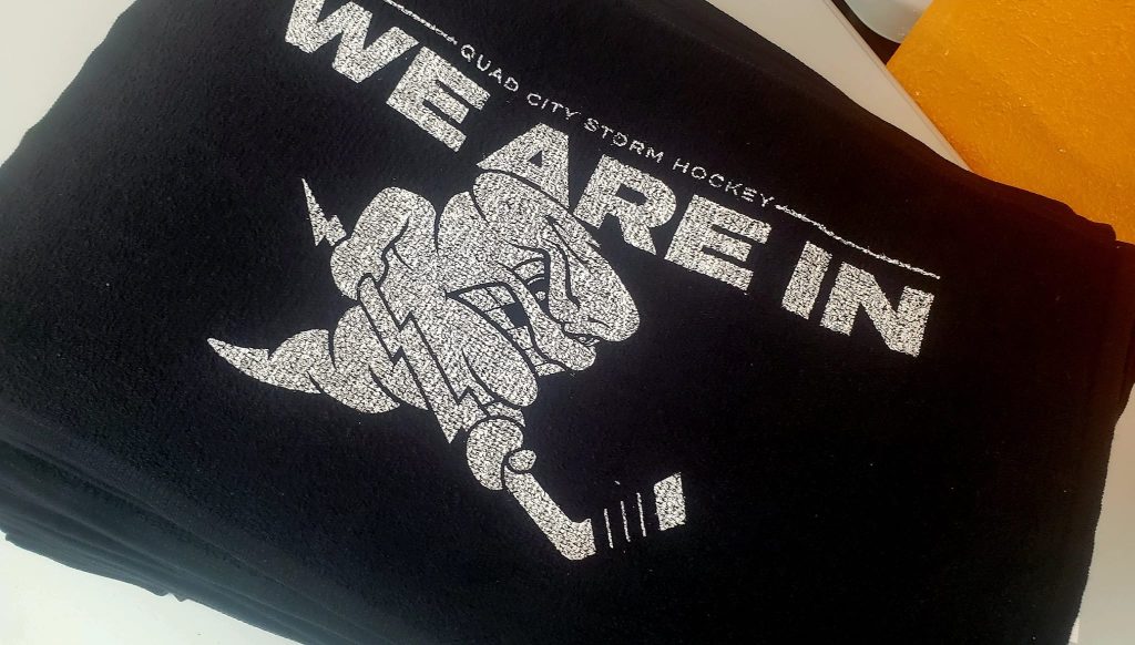 Custom black T-shirt with "WE ARE IN" and storm hockey logo for community team.