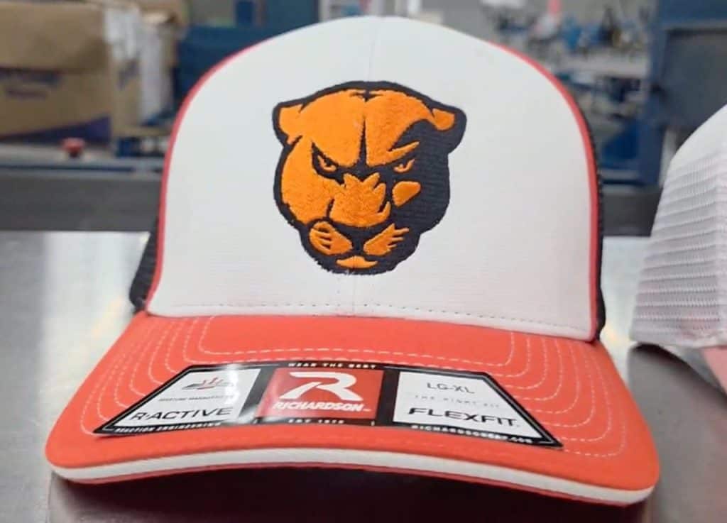 Custom trucker hat with orange and black panther logo for school spirit wear.